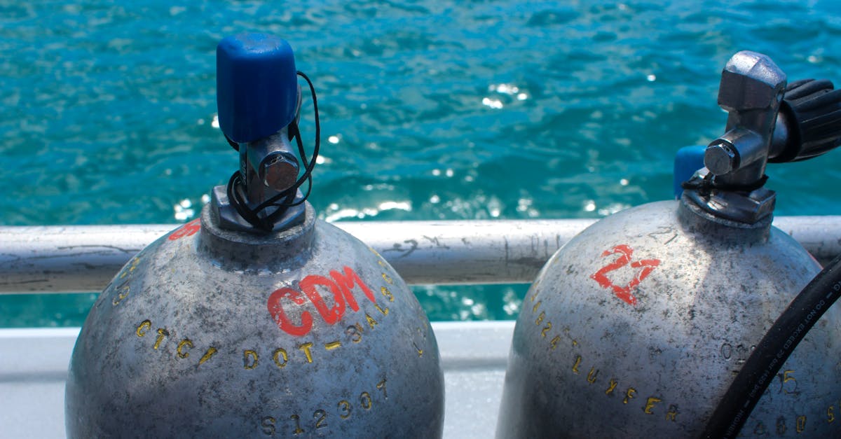 Scuba gear set near a dive boat and tropical shoreline before a dive day.