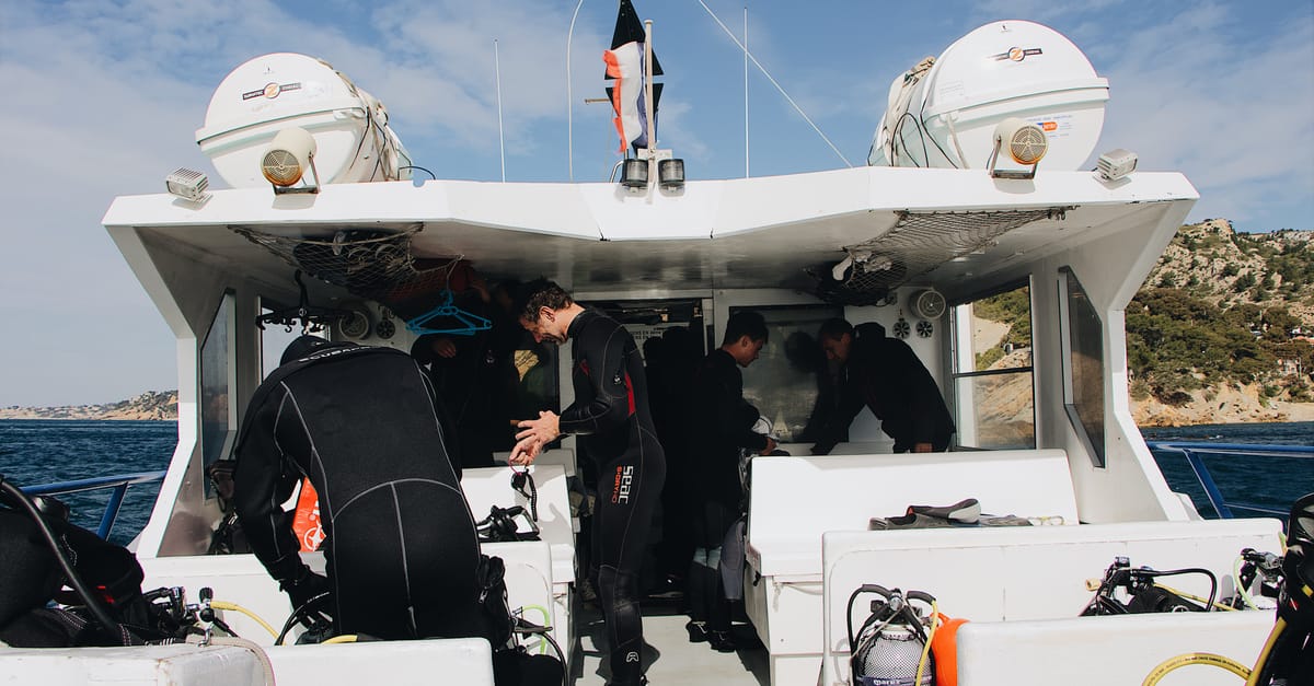 Divers preparing gear on a liveaboard deck before checking the dive plan.