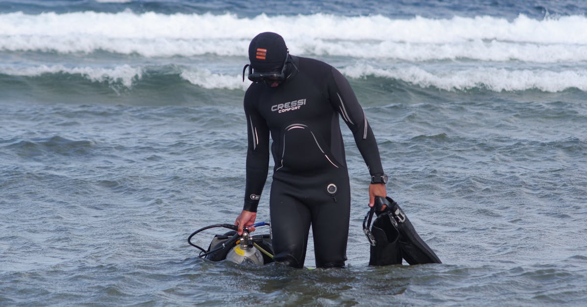 A diver organizing mask, fins, and dry bag items before a scuba trip.