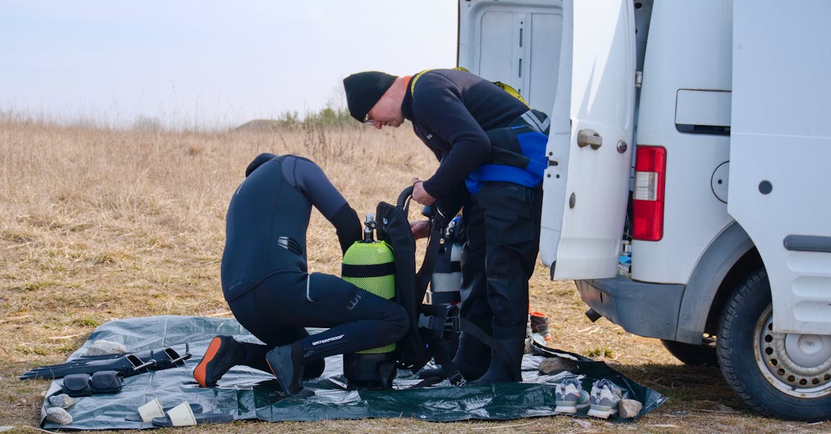 A diver organizing mask, fins, and dry bag items before a scuba trip.