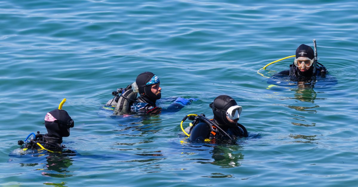 Dive course planning materials beside scuba gear.