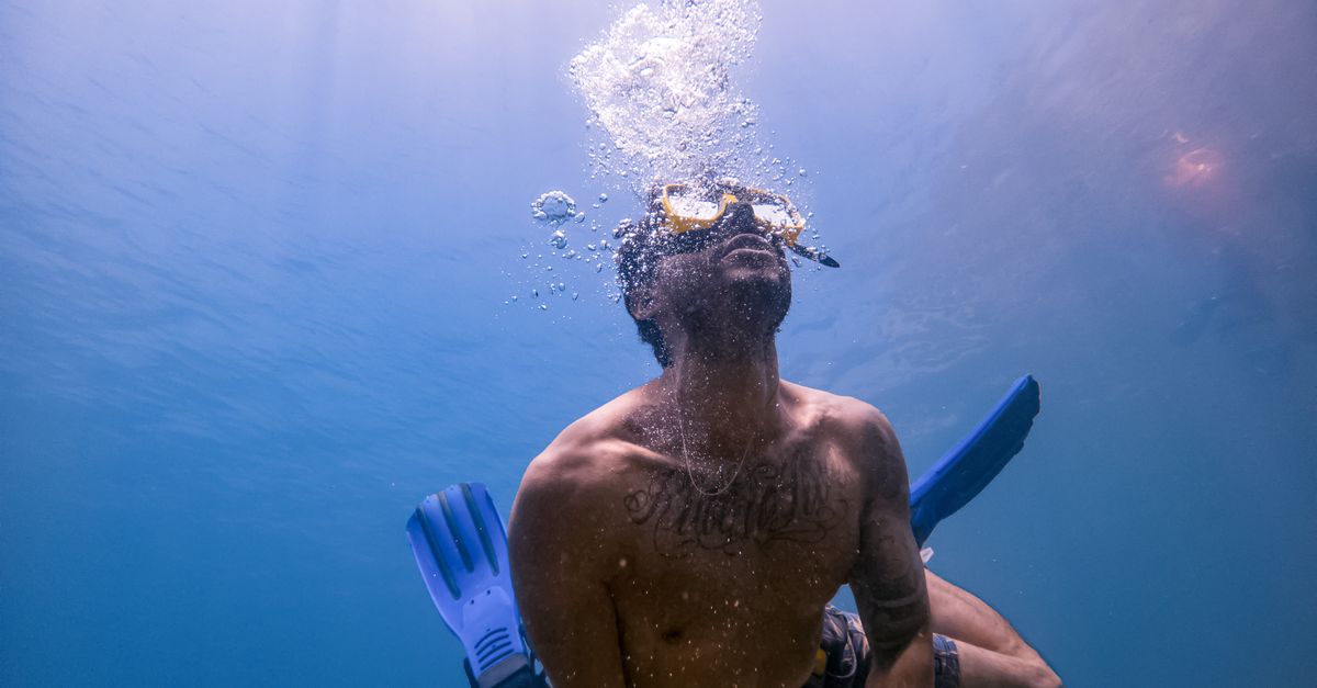 Dive travel planning notes beside scuba gear before asking an operator for quotes.
